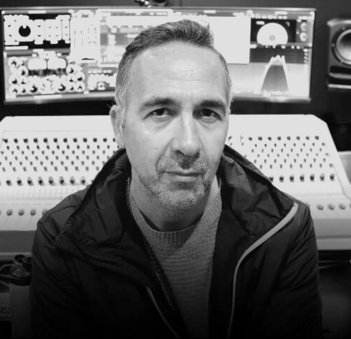 a man in his music studio looking into the camera