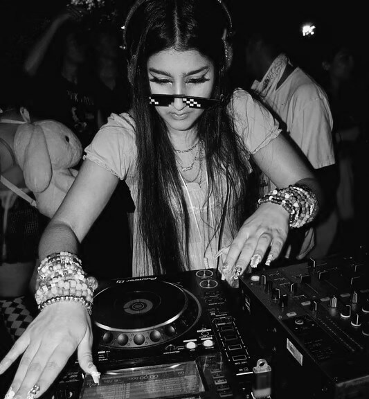 a woman with long black hair onstage djing